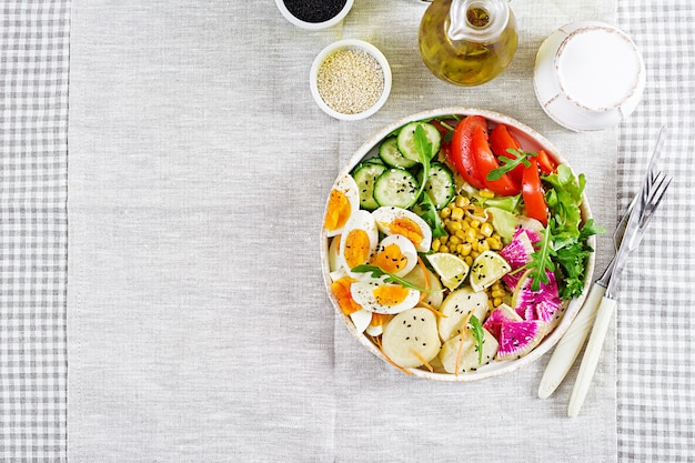 Salada fresca. tigela de buda vegetariano. tigela com batata cozida, pepino, tomate, rabanete melancia, alface, rúcula, milho e ovo cozido.