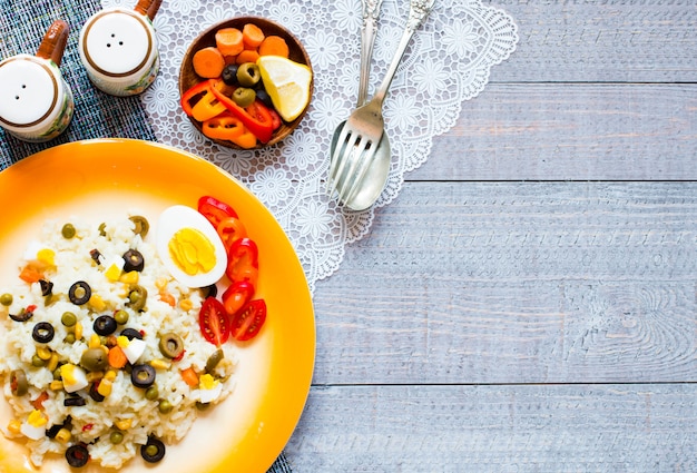 Salada fresca vegetariana com arroz branco sobre fundo de madeira