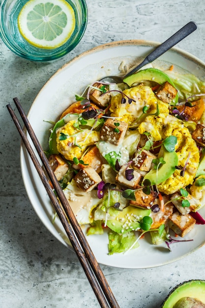 Salada frita de tofu, couve-flor e abacate com brotos. Conceito de comida saudável vegan.