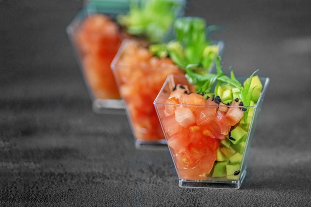 Salada gourmet com abacate e tomate em um fundo cinza Conceito para dieta alimentar e restaurante de comida saudável e restauração