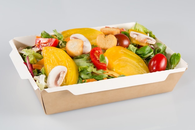 Salada grande em um prato de papelão de um fast food
