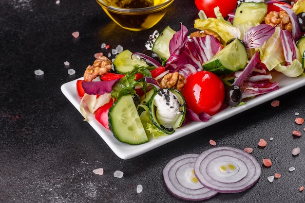 Salada grega com legumes frescos, queijo feta e azeitonas pretas. Salada saudável com tomate cereja, azeitonas orgânicas, pepino, alface e especiarias