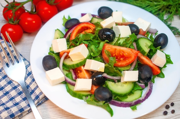 Salada grega com tomates pepinos e queijo feta com azeitonas em cima da mesa