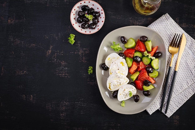 Salada grega de pepino fresco tomate burrata queijo e azeitonas pretas com azeite Comida saudável Vista superior plana lay