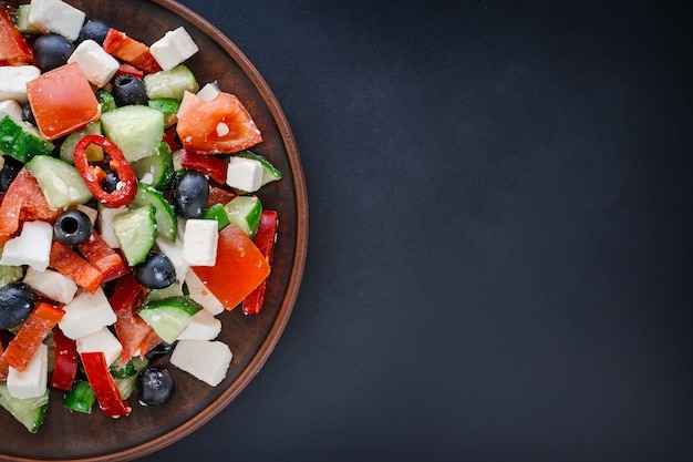 Salada grega em uma placa em um fundo escuro