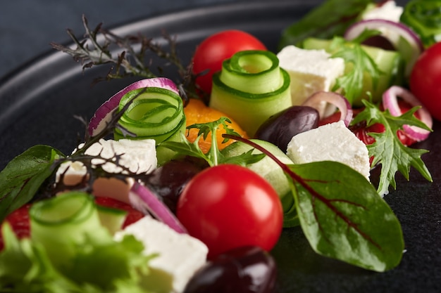 Salada grega fresca com tomate, pepino, pimentão, azeitonas e queijo feta na chapa preta, macro, foco seletivo, estilo de comida