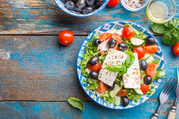 Salada grega fresca de pepino, tomate, pimentão, cebola roxa, queijo feta e azeitonas com azeite. Comida saudável, vista de cima