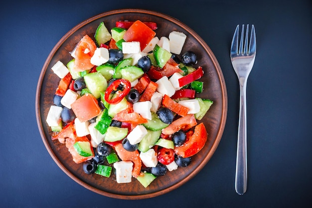 Foto salada grega num prato sobre um fundo escuro