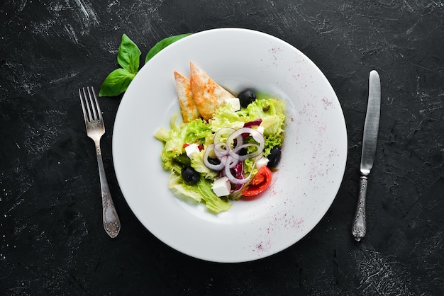 Salada grega Salada de legumes com queijo feta azeitonas e tomate cereja No prato Vista superior Espaço livre para o seu texto Estilo rústico