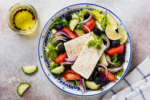 Salada Grega Tradicional. Prato vegetariano com alface fresca, azeitonas, pimentos, pepinos, cebolas e queijo feta. Vista do topo.