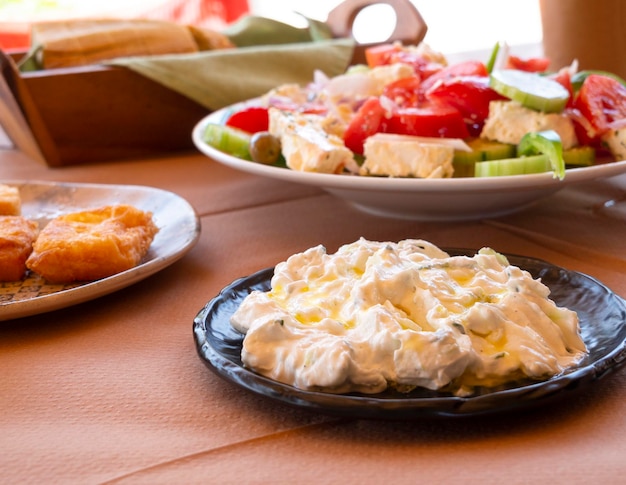 Salada grega tzatziki queijo grelhado vinho caseiro na mesa na estância turística na Grécia