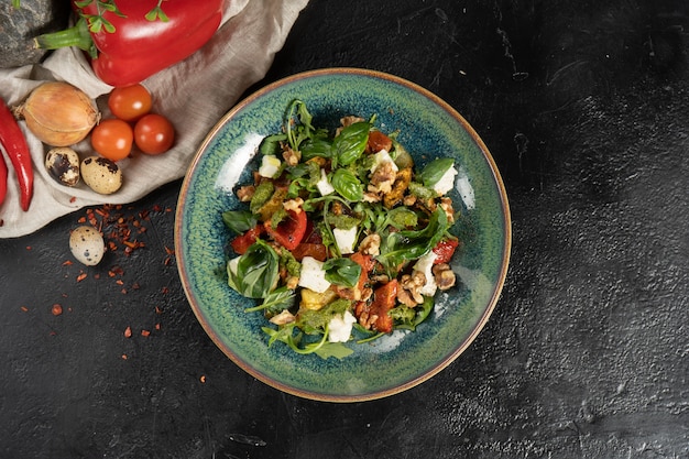 Salada grega vegetariana com manjericão, rúcula, nozes, tomates secos, molho pesto e queijo feta