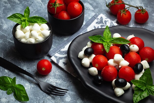 Foto salada italiana clássica caprese com tomates cereja mozarela pérolas folhas de manjericão e esmalte balsâmico