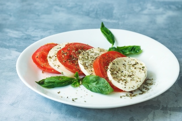 Salada italiana tradicional com tomate maduro, queijo muçarela com folhas frescas de manjericão