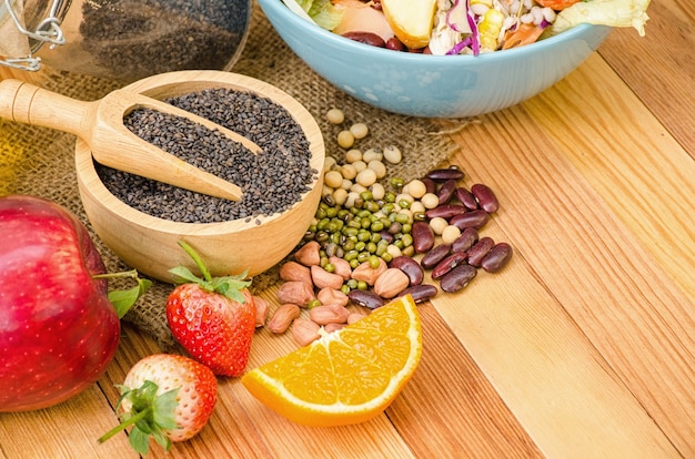 Salada legumes frescos e frutas na mesa de madeira