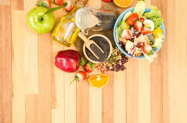 Foto salada legumes frescos e frutas na mesa de madeira