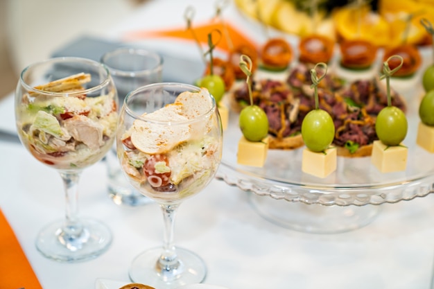 Salada na taça e canapés à vontade na mesa do bufê