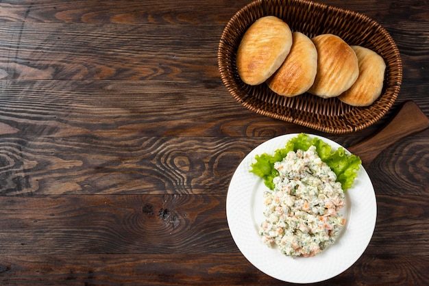 Salada olivier com composição na placa de madeira