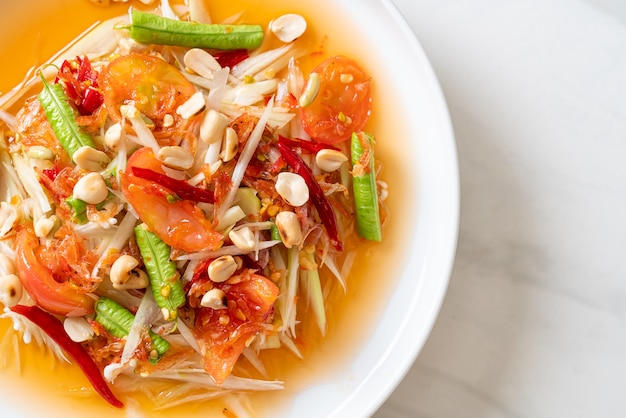 Foto salada picante de mamão - somtam - comida de rua tradicional tailandesa