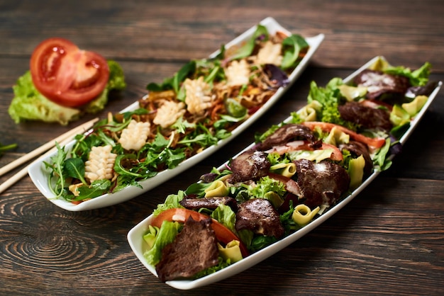 Salada quente com soja lula brotos de carne de abacate rúcula na receita da cozinha asiática em chapa branca detalhes vista superior