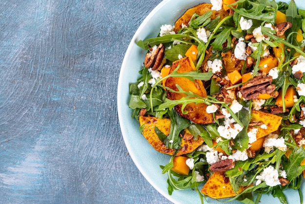 Salada quente de outono Salada caseira de outono com grelha e abóbora assada, rúcula, queijo feta e nozes trituradas Idéia de salada paleo vegana completa de frutas e vegetais