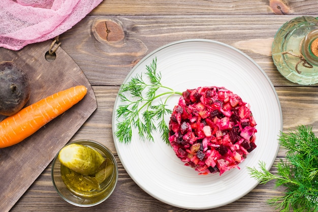 Salada russa nacional - vinagrete - de legumes cozidos, chucrute e pepinos em conserva em um prato