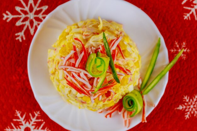 Salada saborosa com carne de caranguejo, milho, pepino e ovos para a ceia de natal. vista do topo.