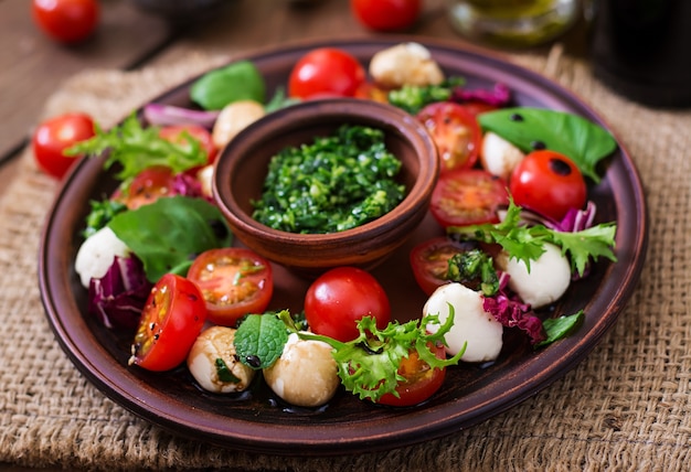 Foto salada salado caprese e mussarela com manjericão e ervas de fundo preto