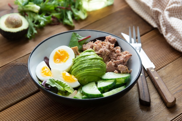 Salada saudável de atum e ovo com abacate e salada verde fresca mistura de folhas.