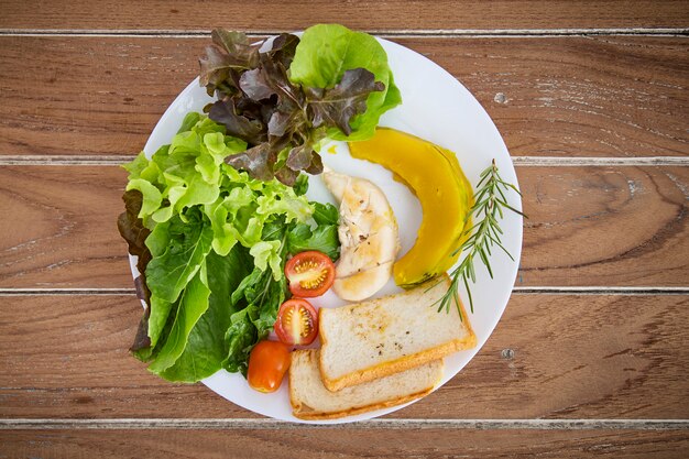 Salada saudável na chapa branca na mesa de madeira Espaço para conceber a comida saudável conceitos