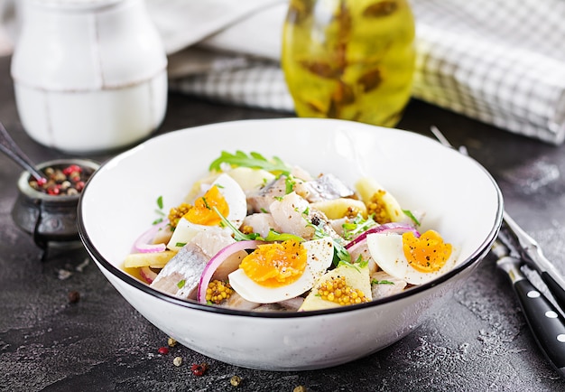 Salada tradicional da faixa de arenques salgados, maçãs frescas, cebola vermelha e ovos.