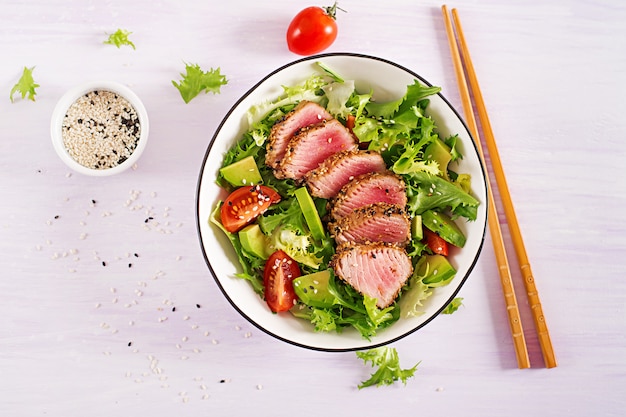 Salada tradicional japonesa com pedaços de atum Ahi grelhado médio-raro e gergelim com legumes frescos em uma tigela.