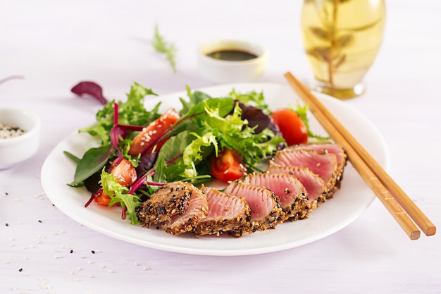 Salada tradicional japonesa com pedaços de atum Ahi grelhado médio-raro e gergelim com salada de legumes fresca em um prato