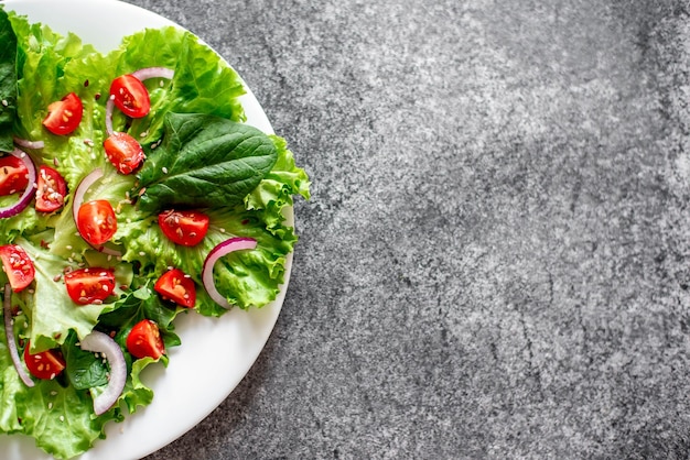 Salada vegana verde de vegetais e folhas verdes misturadas em fundo de pedra