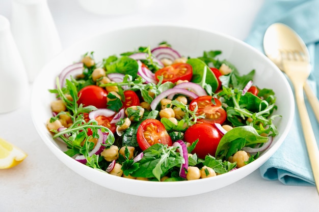 Salada vegetariana de grão-de-bico com tomate, rúcula, salsa, espinafre e cebola roxa Dieta alimentar saudável