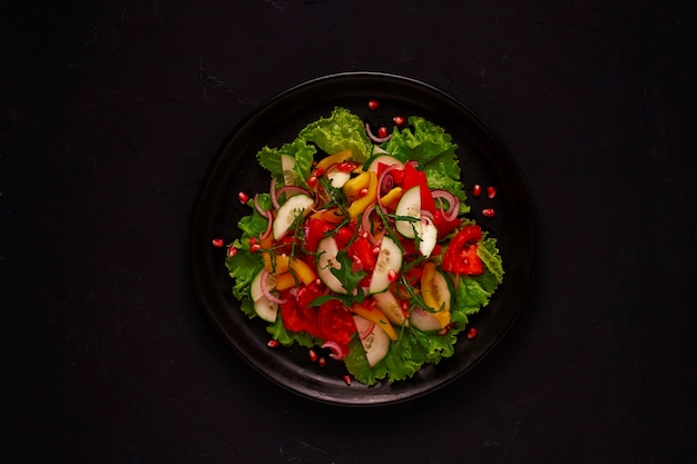 Salada vegetariana fresca, feita de vegetais, em um fundo preto, visão superior da nutrição adequada, sem pessoas, horizontal. foto de alta qualidade