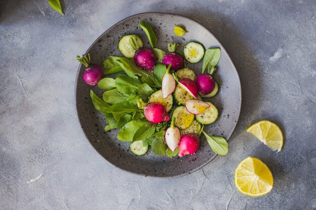 Salada verde com rúcula, rabanete, pepino e azeite. conceito de comida saudável.