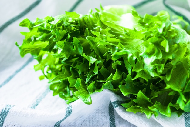 Salada verde em uma toalha de cozinha listrada