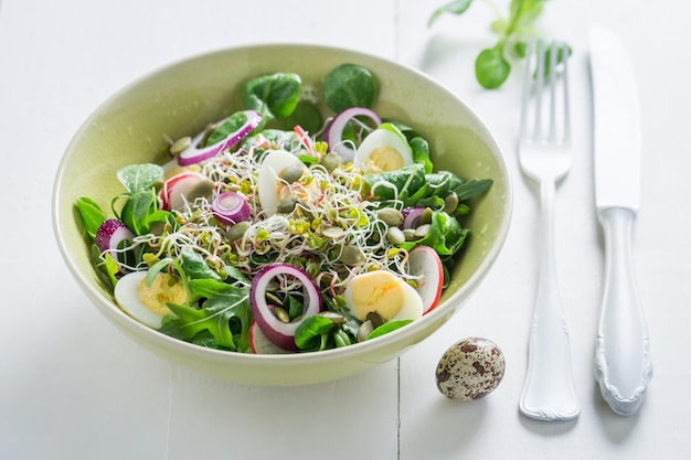 Salada verde fresca com ovo de codorna de cebola e brotos