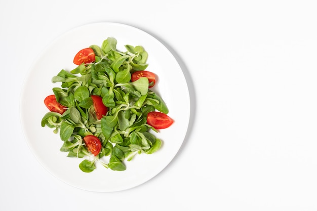 Salada verde fresca com tomates em branco