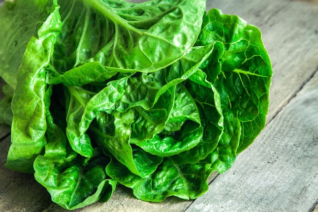 Salada verde orgânica madura Romano em fundo de madeira rústica