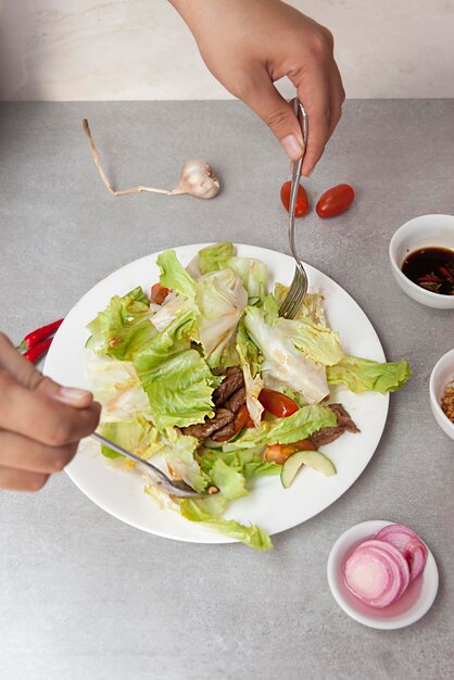 Salada vietnamita agitando carne, tigelas e pratos com vista superior de comida