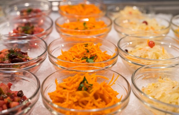 Saladas em tigelas na cozinha aberta do restaurante estão em fila