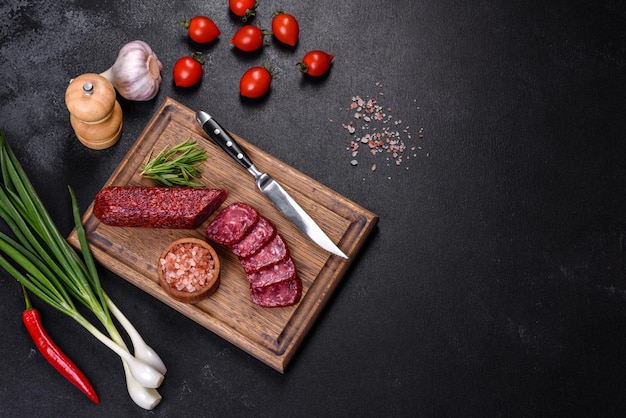 Salame defumado com alho alecrim e tomate na tábua de madeira