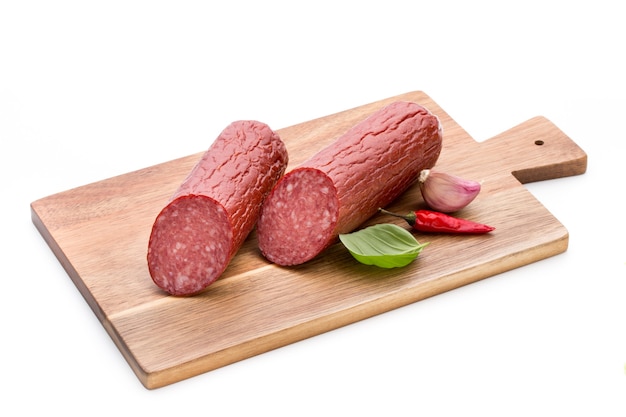 Salame, salame, folhas de manjericão, recorte de superfície branca.