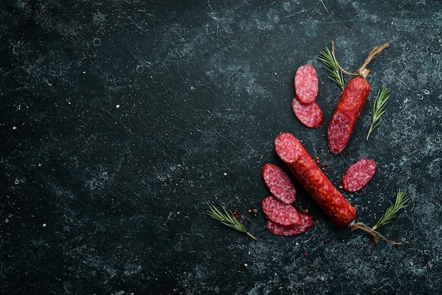 Salame tradicional defumado com especiarias Salsichas em fatias Alecrim Vista superior Espaço livre para o seu texto