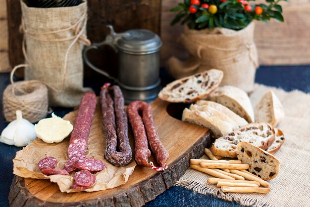 salame variado em uma placa de madeira e pão