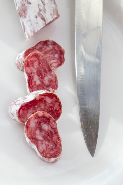 Salami cortado con una hoja de cuchillo