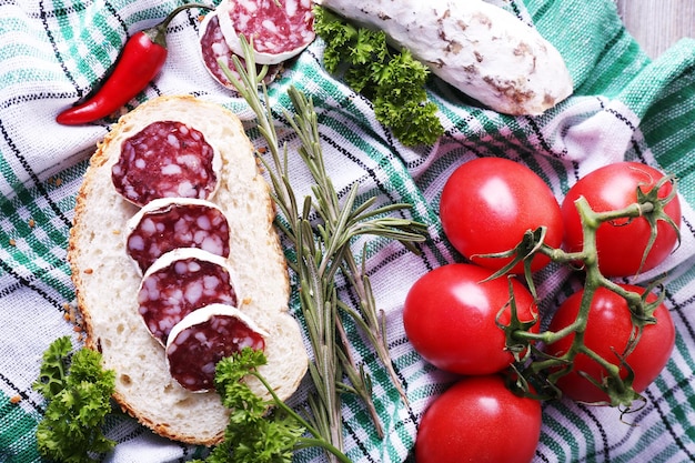 Salami francés con tomates de pan y perejil sobre fondo de tela