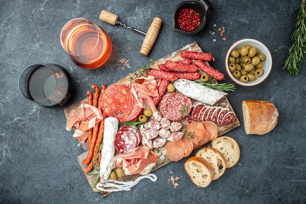 Salami, geschnittener Schinken, Wurst, Schinken, Speck, Toast, Oliven, Fleisch-Antipasti-Platte und Rotwein